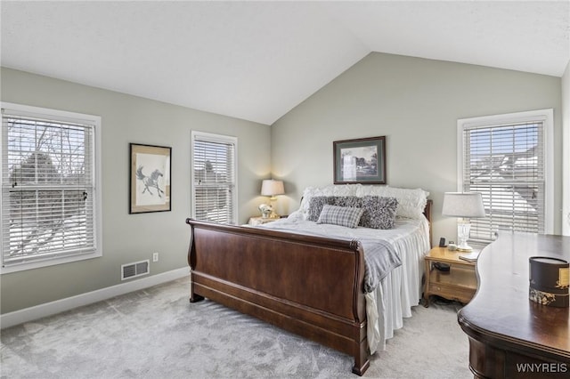 bedroom with vaulted ceiling and light colored carpet