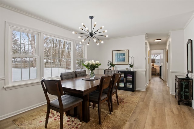 dining room featuring a notable chandelier, light hardwood / wood-style flooring, and crown molding