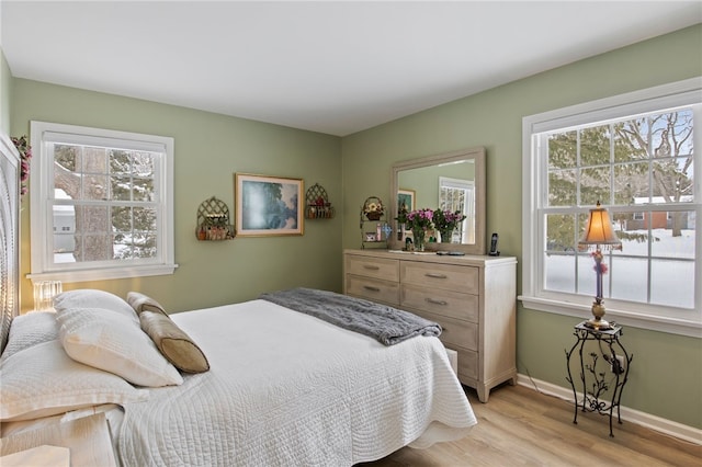 bedroom with multiple windows and light hardwood / wood-style floors