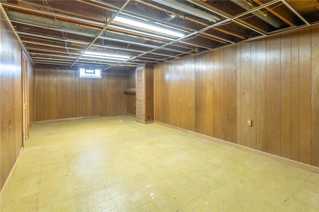 basement featuring wooden walls