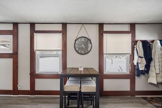 dining space featuring a textured ceiling and wood-type flooring