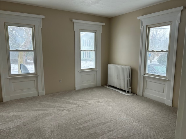 carpeted empty room featuring radiator