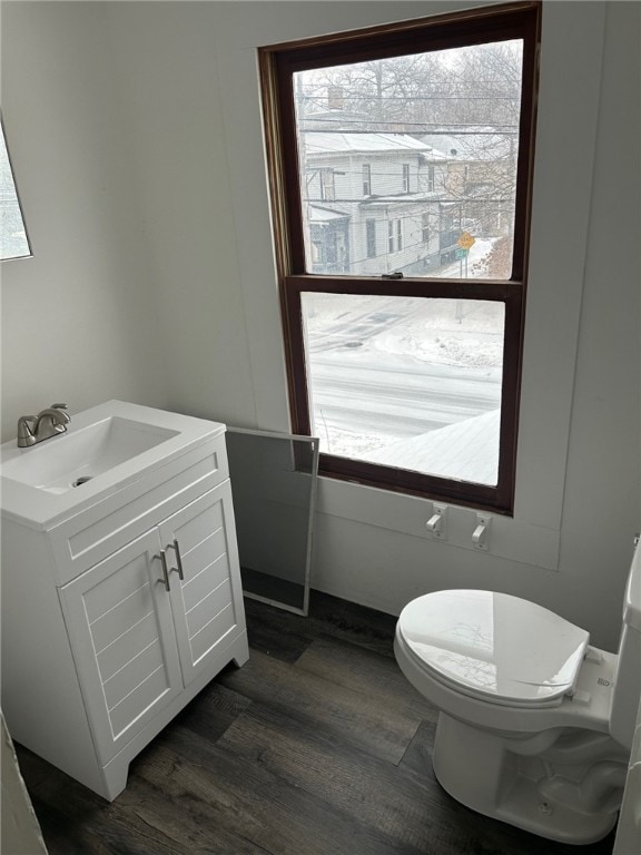 bathroom with hardwood / wood-style flooring, toilet, plenty of natural light, and vanity