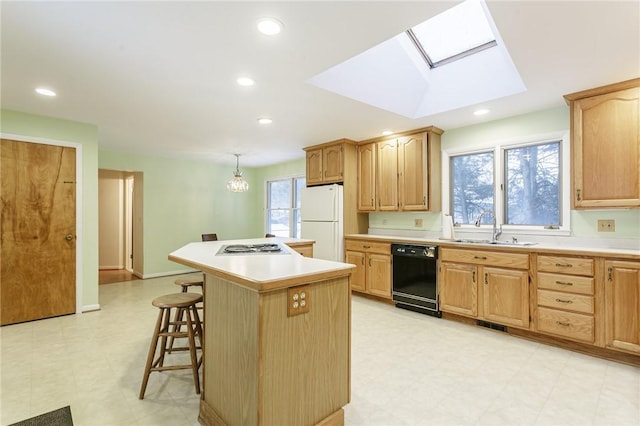 kitchen with light countertops, a kitchen island, freestanding refrigerator, and black dishwasher