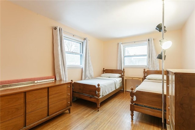 bedroom featuring multiple windows and light wood-style floors