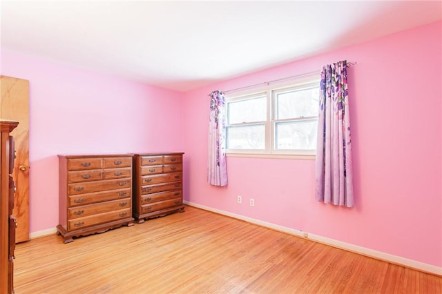 unfurnished bedroom featuring baseboards and light wood finished floors