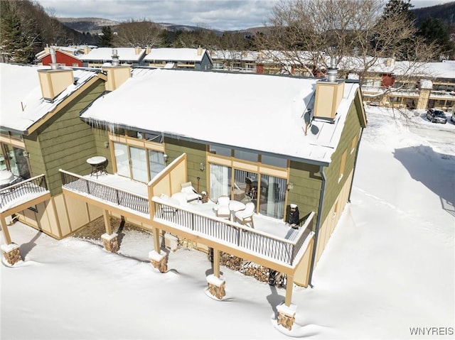 view of snow covered back of property