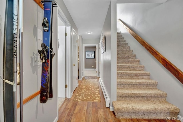 interior space with wood-type flooring and a baseboard heating unit