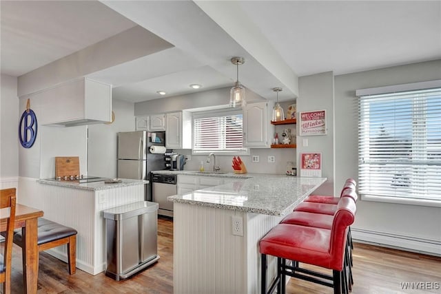 kitchen featuring kitchen peninsula, stainless steel appliances, and a breakfast bar area