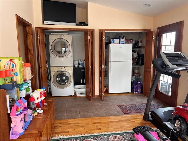 washroom featuring stacked washer / dryer and dark hardwood / wood-style floors