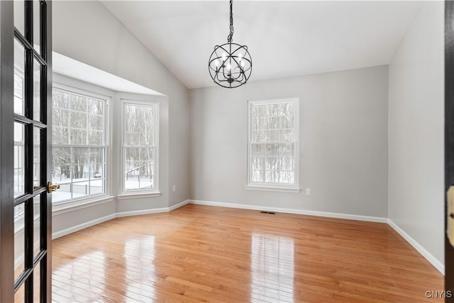 unfurnished room featuring light wood finished floors, plenty of natural light, visible vents, and baseboards