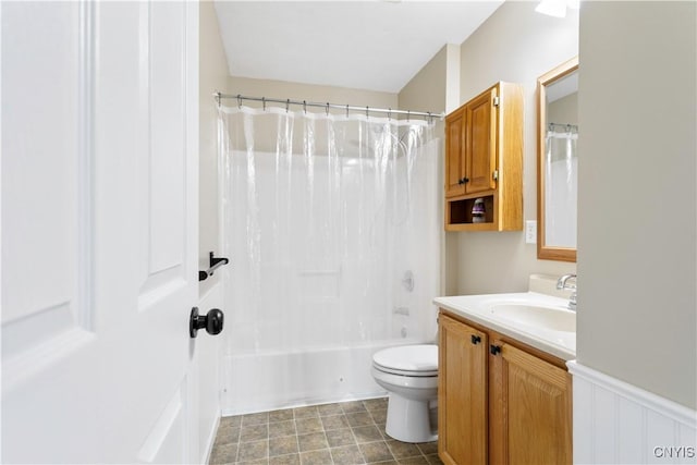 bathroom featuring toilet, a wainscoted wall, shower / bath combo, and vanity