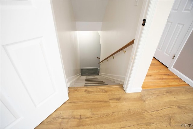 stairway with baseboards and wood finished floors