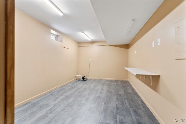 below grade area featuring wood finished floors and baseboards