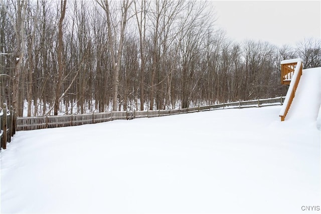 yard layered in snow with fence