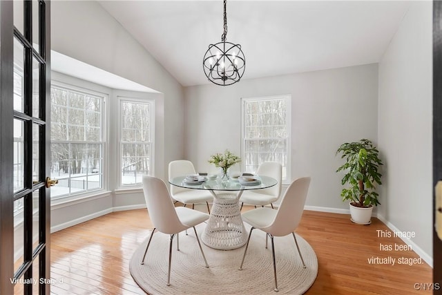 dining area with a notable chandelier, vaulted ceiling, light wood-type flooring, and baseboards