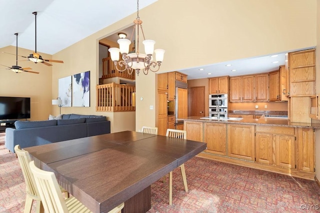 dining room featuring ceiling fan with notable chandelier and high vaulted ceiling