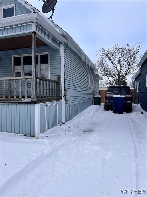 snow covered property featuring covered porch