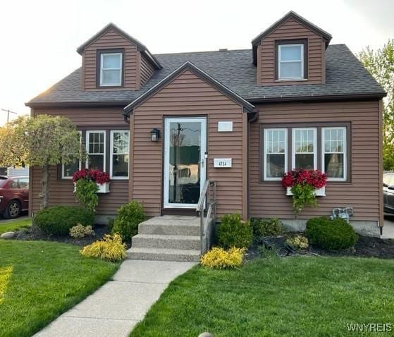 cape cod house with a front yard