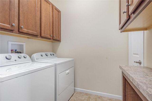 clothes washing area featuring cabinets and washing machine and dryer