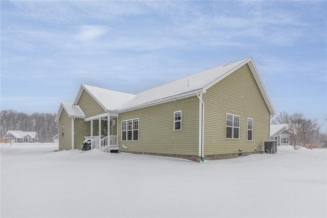 snow covered property featuring cooling unit