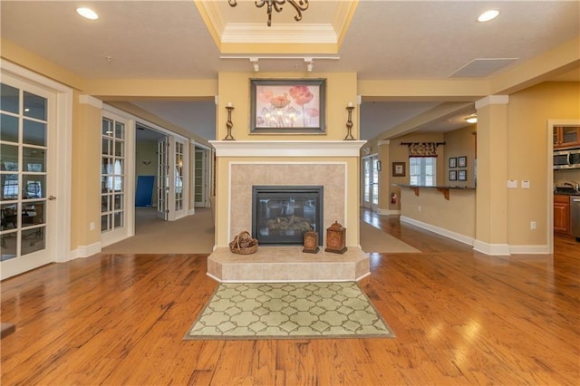 5134 Cheshire Glen Rd Unit 240A, Canandaigua-Town, NY 14424 - unfurnished living room featuring a raised ceiling, a tiled fireplace, wood-type flooring, and ornamental molding