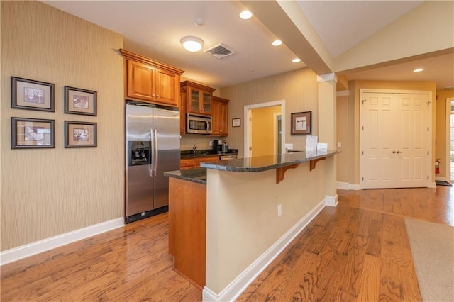 5134 Cheshire Glen Rd Unit 240A, Canandaigua-Town, NY 14424 - kitchen featuring dark stone countertops, a kitchen bar, stainless steel appliances, and light hardwood / wood-style floors