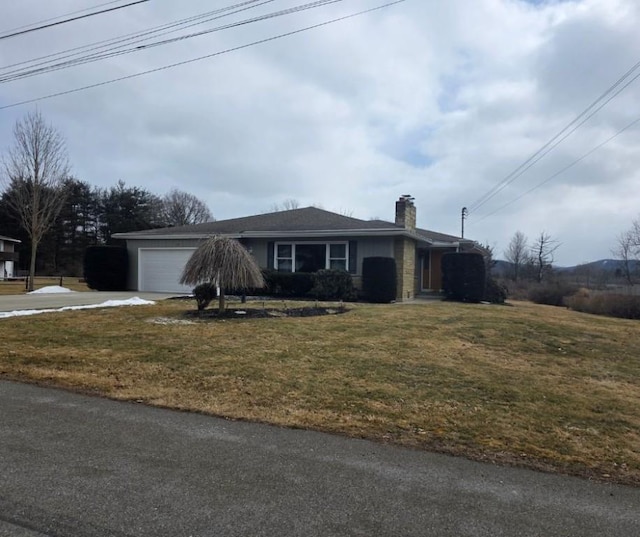 single story home featuring concrete driveway, an attached garage, a front lawn, and a chimney