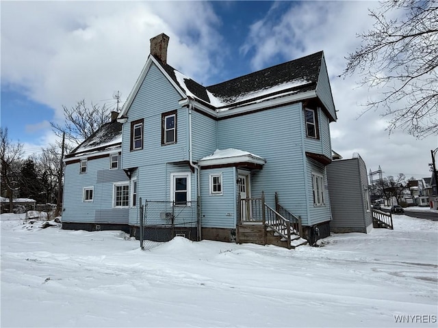 view of snow covered back of property