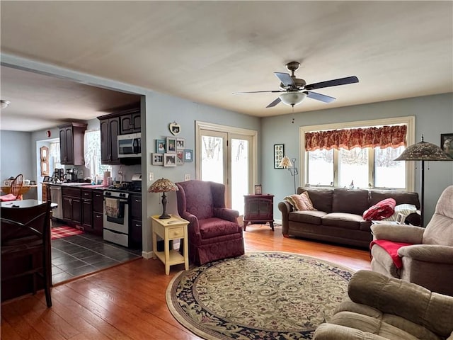 living room with ceiling fan and dark hardwood / wood-style flooring