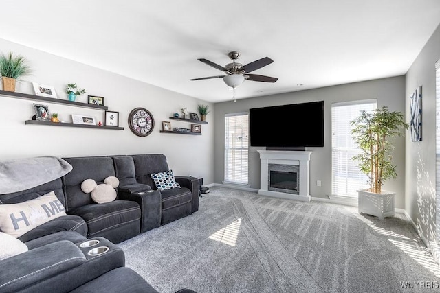 living room featuring ceiling fan, carpet floors, and a fireplace