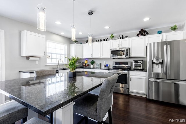 kitchen with hanging light fixtures, stainless steel appliances, and a kitchen island