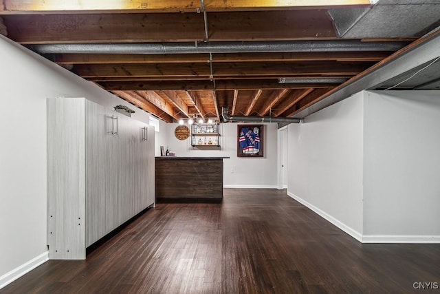 basement featuring dark hardwood / wood-style floors and indoor bar