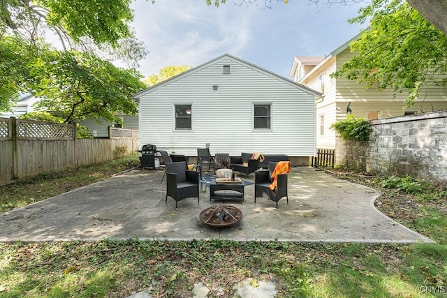 back of property featuring a patio area and an outdoor living space with a fire pit