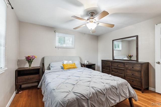 bedroom featuring multiple windows, ceiling fan, and wood-type flooring