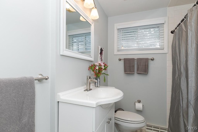 bathroom with toilet, vanity, and walk in shower