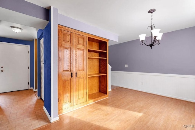 interior space featuring light hardwood / wood-style floors, a chandelier, and built in features