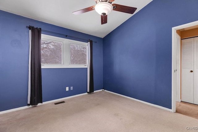 carpeted empty room featuring lofted ceiling and ceiling fan