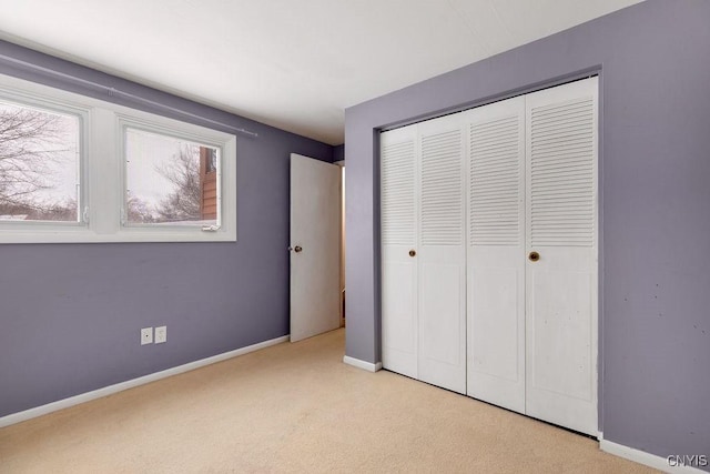 unfurnished bedroom featuring a closet and light carpet