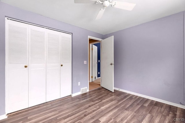 unfurnished bedroom featuring ceiling fan, a closet, and hardwood / wood-style floors