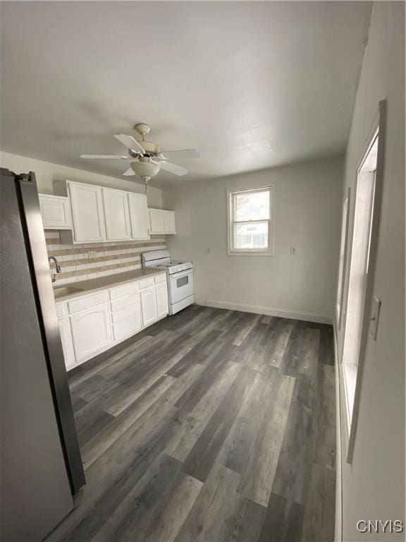 kitchen featuring gas range gas stove, stainless steel refrigerator, tasteful backsplash, white cabinets, and dark hardwood / wood-style floors