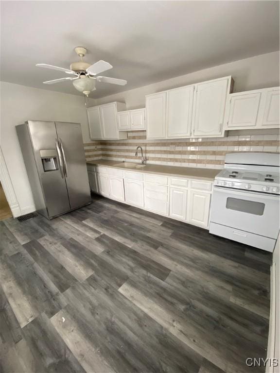 kitchen with tasteful backsplash, stainless steel refrigerator with ice dispenser, white gas stove, dark hardwood / wood-style flooring, and white cabinetry