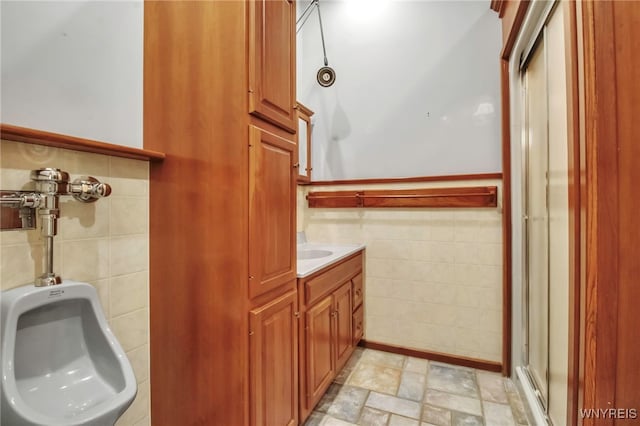 bathroom featuring tile walls, vanity, and an enclosed shower