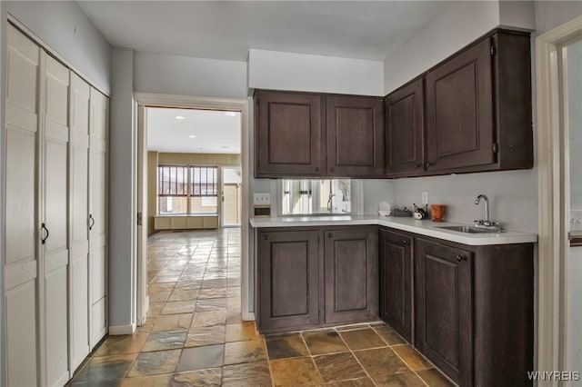 kitchen featuring sink, dark brown cabinetry, and kitchen peninsula