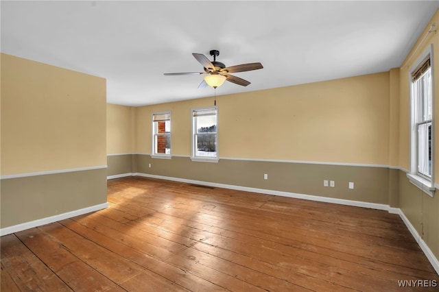 empty room featuring ceiling fan, hardwood / wood-style flooring, and a healthy amount of sunlight