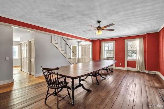 dining area with ornamental molding, a wealth of natural light, and wood-type flooring