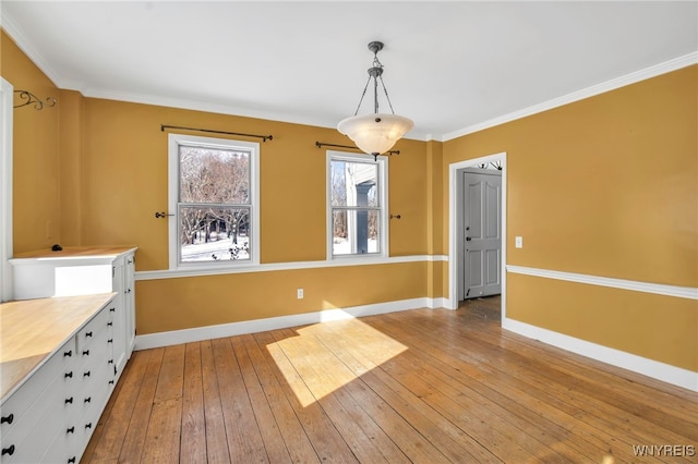 unfurnished dining area featuring light hardwood / wood-style flooring and ornamental molding