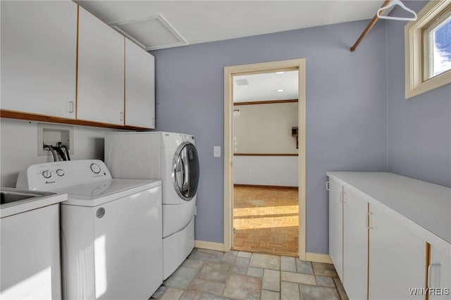 laundry area with independent washer and dryer and cabinets