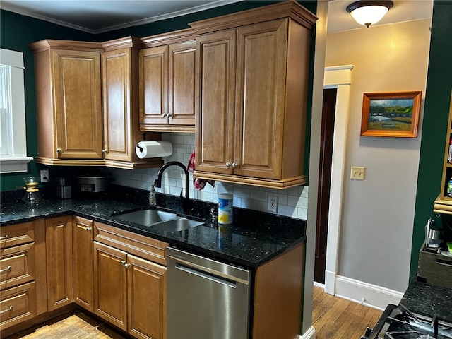 kitchen with sink, dark stone counters, stainless steel dishwasher, and backsplash