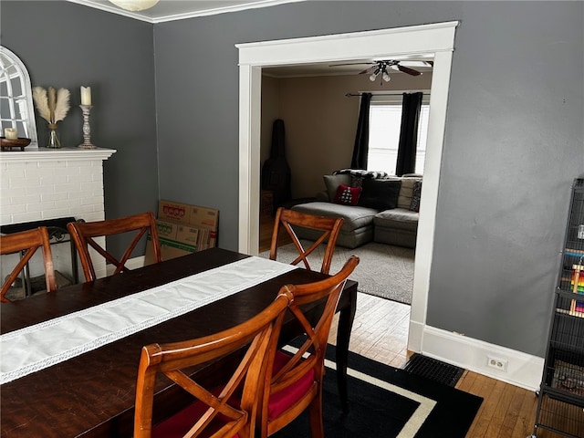146 N Broad St, Norwich-City, NY 13815 - dining area with ornamental molding, a brick fireplace, ceiling fan, and wood-type flooring